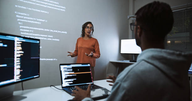 Hispanic Latin American software engineer developer use laptop computer program coding, projection screen presentation. Programming language development, business technology, night work people concept